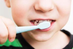 child's teeth with a toothbrush photo