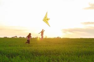 Family launches a kite in the field photo