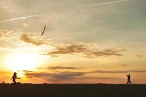 Family launches a kite in the field photo