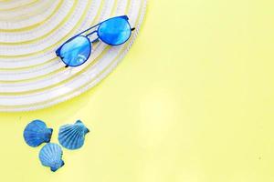 Travel vacation background. Sun glasses sea shells yellow background. Concept summer holidays. photo