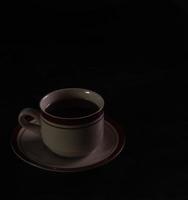 taza de té aislado en un fondo negro foto