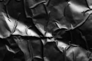 black crumpled and creased plastic poster texture background photo