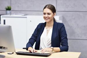 Close up portrait of attractive smiling businesswoman at workplace photo
