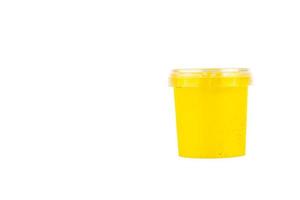 Yellow watercolor paint in a jar. White isolated background. photo