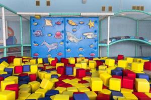 parque infantil con bloques de colores suaves y un muro de escalada azul. foto