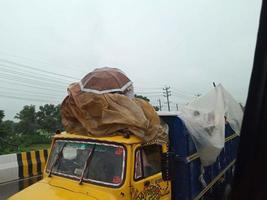 personas subiendo al techo del tren para ir a sus distritos de origen en una carretera transitada eid journy de personas pobres en bangladesh que viajan en la época de lluvias en bangladesh durante la temporada de eid foto