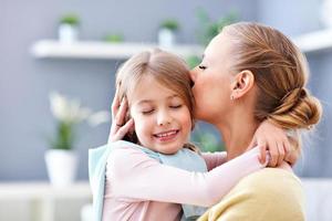 Beautiful mom and her daughter having fun at home photo