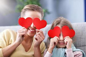 Beautiful mom and her daughter having fun at home photo