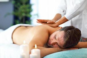 Handsome man having massage in spa salon photo