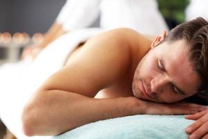 Handsome man having massage in spa salon photo