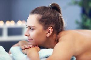 mujer feliz con masaje en el salón de spa foto