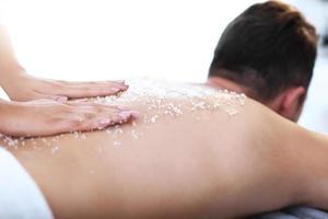 Handsome man having massage in spa salon photo