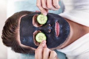 Handsome man having facial in spa salon photo