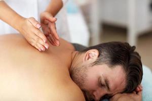 Handsome man having massage in spa salon photo