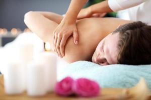 Handsome man having massage in spa salon photo