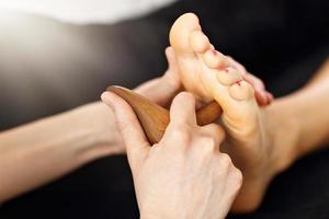 mujer recibiendo un masaje de pies tailandés en el spa de salud foto
