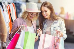 Girl friends shopping for clothes in store photo