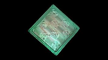 Green glass decorates house with low light techniques, surface of carved glow transparent squares tile pronounced pattern. Selective focus black background. photo