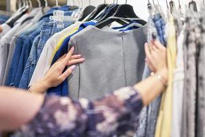 mujer feliz comprando ropa en la tienda foto