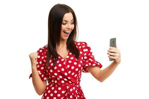 Caucasian brunette woman using smartphone isolated over white background photo