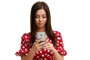Caucasian brunette woman using smartphone isolated over white background photo