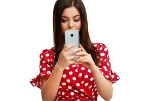 Caucasian brunette woman using smartphone isolated over white background photo