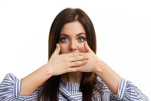 Shocked girl covers her face with hands isolated on white photo