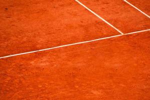 New outdoor orange tennis courts with white lines. New worn out tennis court. photo