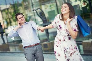 retrato de pareja feliz con bolsas de compras en la ciudad sonriendo y abrazándose. foto