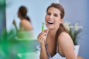 Beautiful brunette woman shaving in the bathroom photo