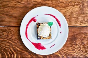 Brownie Sundae with a Scoop of Vanilla Ice Cream and Berry Sauce photo