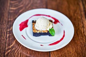 Sundae de brownie con una bola de helado de vainilla y salsa de bayas foto