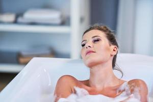 Close-up portrait of a young woman relaxing in the bathtube photo