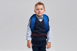 Portrait of a boy ready to school isolated on white photo