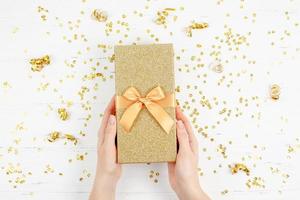 Golden gift box with confetti photo