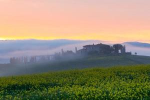 Morning fog view on farmhouse in Tuscany, Italy photo