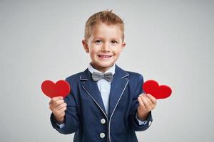 Portrait of happy cute little kid holding red heart photo