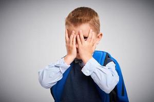 Portrait of a boy ready to school isolated on white photo