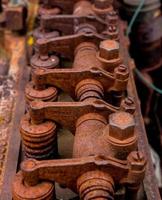 Vintage antique automotive cylinder head rocker shaft and arms covered in rust photo