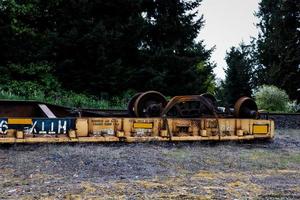 Overturned derailed railroad car lying next to the tracks photo