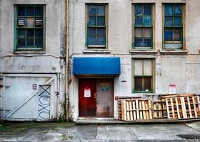 Old building wall with broken windows and doors photo