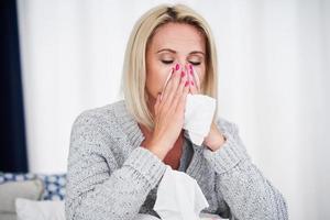 Adult woman feeling unewll with runny nose at home photo