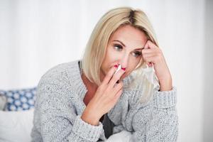 Adult woman feeling unewll with runny nose at home photo