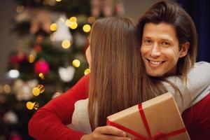 hija y padre con regalo sobre el árbol de navidad foto