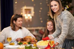 Beautiful family eating Christmas dinner at home photo