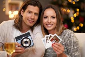 hermosa pareja celebrando la navidad en casa y tomando fotos instantáneas