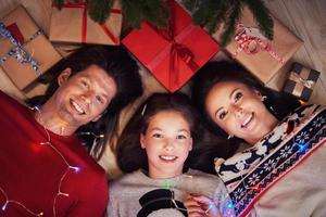 hermosa familia con regalos bajo el árbol de navidad foto