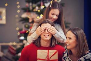 Beautiful family with presents over Christmas tree photo