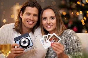 hermosa pareja celebrando la navidad en casa y tomando fotos instantáneas