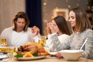 Beautiful family praying over festive dinner at home photo